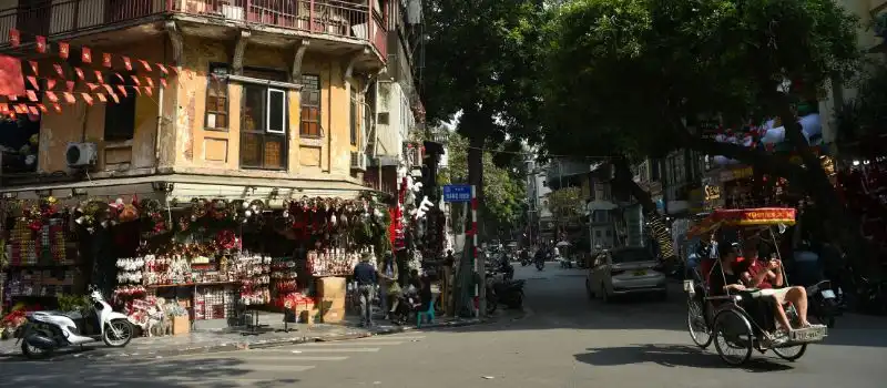 Scène de rue animée à Hanoi avec des pousse-pousse Scène de rue animée à Hanoi avec des pousse-pousse